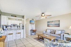 A compact living space with a kitchenette, a dining area, and a seating area with a sofa and a coffee table. - Summer House West B105 (Gulf Shores)