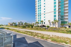 Ein mehrstöckiges Hotel mit Balkonen, einem Parkplatz und Blick auf den Strand.