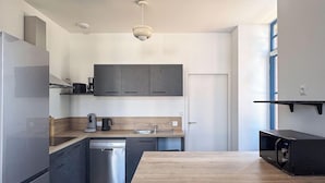Una cocina moderna con una isla central, electrodomésticos integrados y un diseño minimalista.