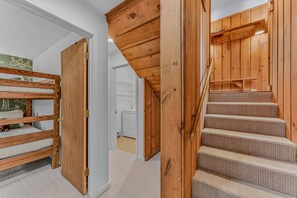 Eine Holztreppe mit Geländer, die zu einer zweiten Etage führt.