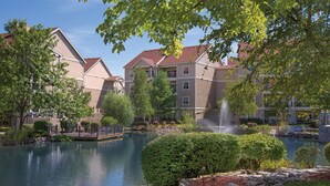 Un ensemble immobilier résidentiel comprenant un étang, une fontaine et un quai.