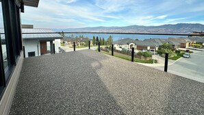 Una zona residencial con casas, una calle y un cuerpo de agua al fondo.