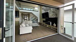 Una sala de estar moderna con un sofá modular, un televisor de pantalla plana y una chimenea.