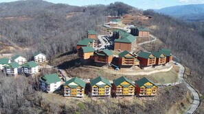 A lodge with multiple buildings, a parking area, and a winding road. - Gatlinburg, TN. Footsteps away from the Smokey Mountains (Gatlinburg)