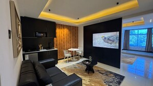 Ein modernes Wohnzimmer mit einer Couch, einem Couchtisch und einem Fernseher, der ein Bild zeigt.