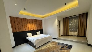 Ein modernes Schlafzimmer mit einem Bett, einem gemusterten Teppich und einer Wand in Holzoptik.