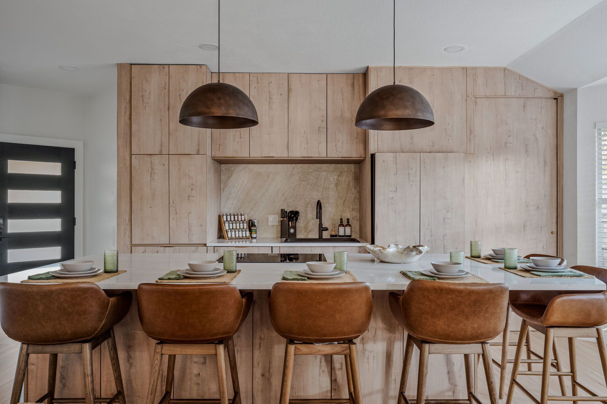 Une cuisine moderne avec des meubles en bois, un îlot central et des luminaires suspendus.