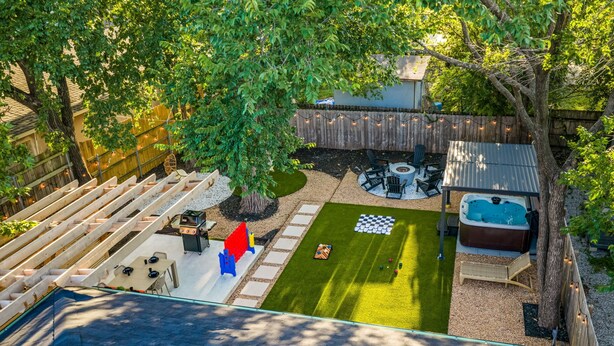 Ein Garten mit Whirlpool, Feuerstelle und Tischtennisplatte.