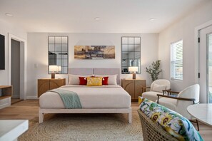 A modern bedroom with a large bed, bedside tables, a chair, and a small table. - Onyx & Oak - Hot Tub & Backyard Oasis, East Austin (Austin)