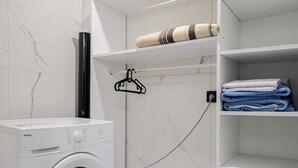 A laundry area with a washing machine, a hanging rack, and shelves with folded towels. - 4-deluxe Villa With Heated Private Pool (Dilovasi)