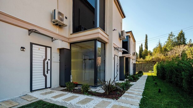 A modern two-story house with large windows, a front door, and a pathway leading to the entrance. - 4-deluxe Villa With Heated Private Pool (Dilovasi)