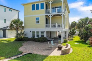 A two-story building with a covered patio area, outdoor seating, and a fire pit. - Coastal Canary - Hot tub, beach, fire pit (Flagler Beach)