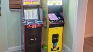 Huoneessa on kaksi peliautomaattia, ja seinät ovat vaaleanvihreät sekä lattia puuta.