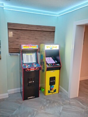 Zwei Spielautomaten in einem Raum mit hellgrünen Wänden und Holzboden.