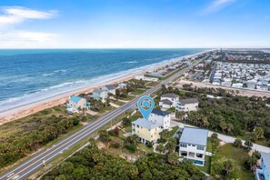 An aerial view of a coastal residential area with a beachfront, a road, and a hotel icon indicating a hotel presence. - Coastal Canary - Hot tub, beach, fire pit (Flagler Beach)