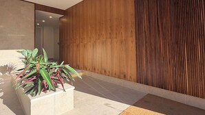 Un interior moderno con una pared de madera, piso de baldosas y una planta en maceta.