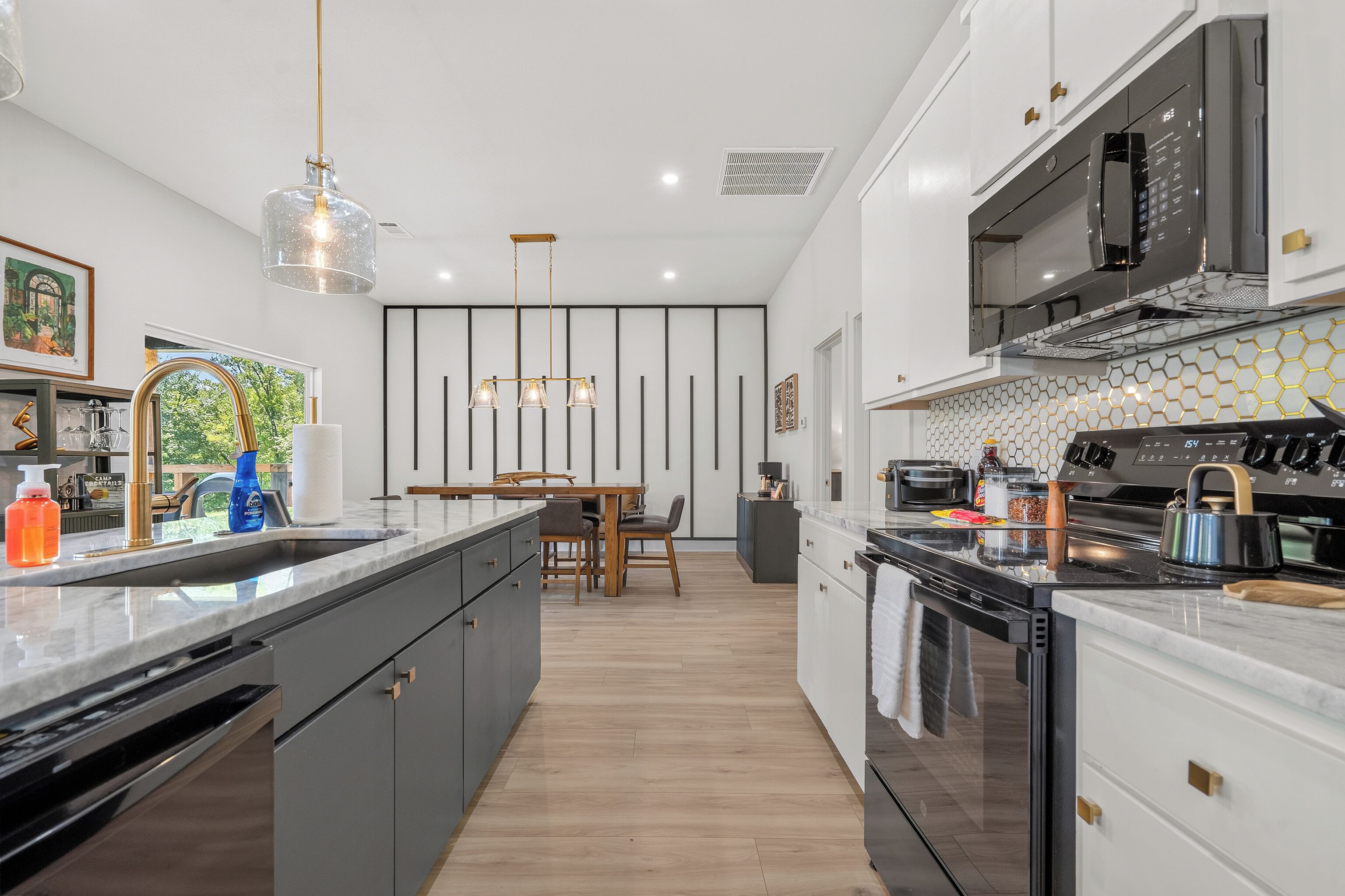 A modern kitchen with a central island, a dining area, and a microwave.