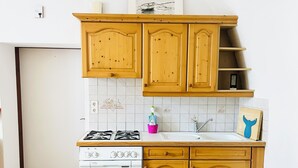 Una cocina con armarios de madera, una estufa blanca y un salpicadero de azulejos.
