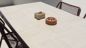A terrace with a table and chairs, overlooking a coastal view. - Borgo Stampalia – Villa Terracotta (Astypalea)