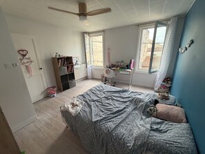 Ein Schlafzimmer mit Bett, Schreibtisch, Stuhl und Bücherregal.
