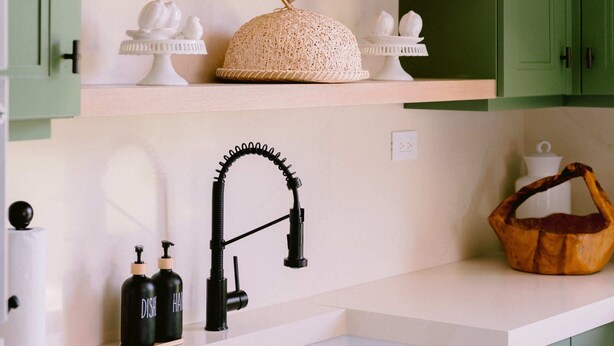 A kitchen with green cabinets, white countertops, and shelves with decorative items. - Elegance 5BR– Tortuga C9 Villa Punta Cana (Punta Cana)