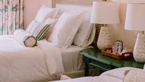 A hotel room with two beds, a green nightstand, a mirror, and a floral curtain. - Elegance 5BR– Tortuga C9 Villa Punta Cana (Punta Cana)