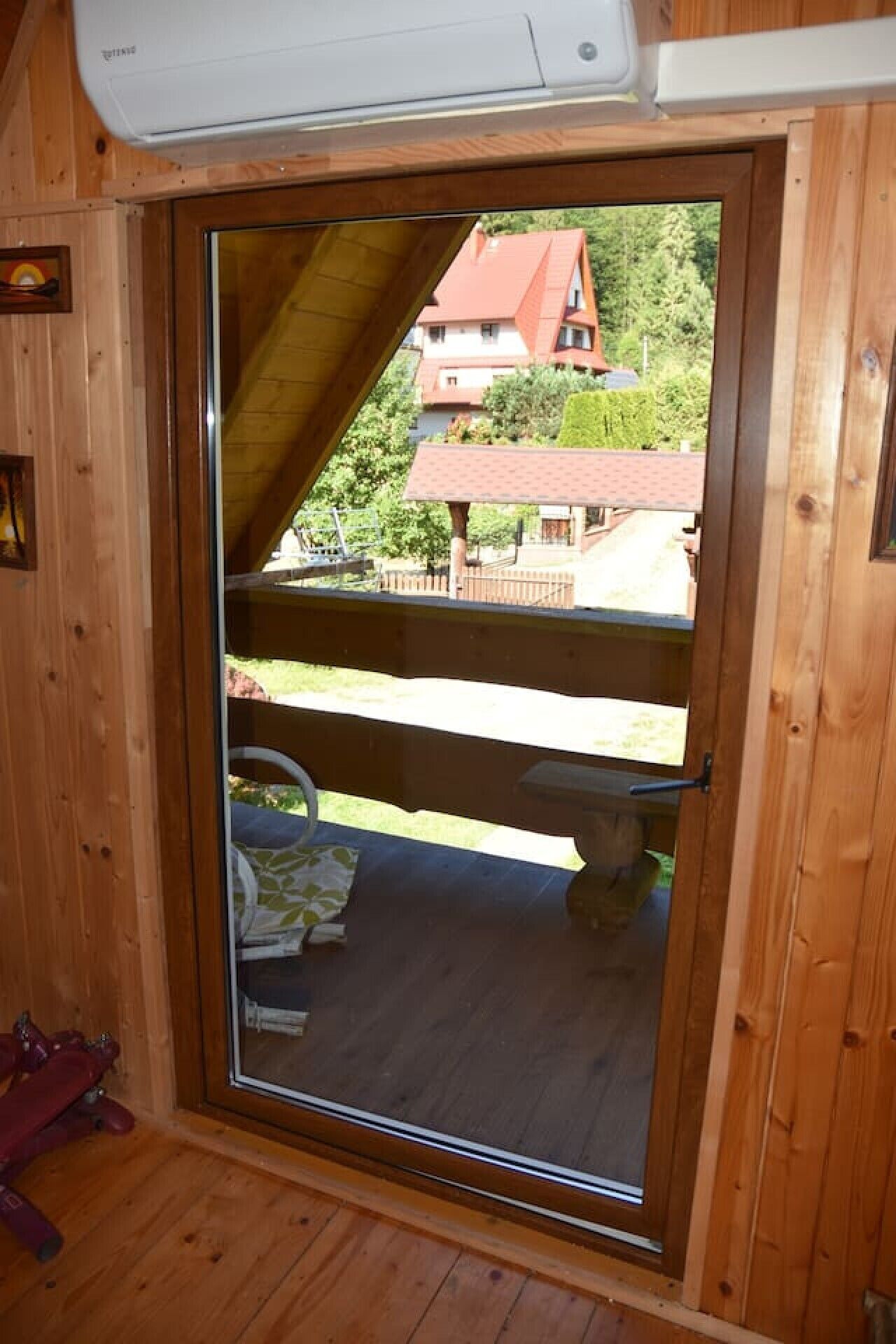 A wooden interior with a sliding glass door leading to an outdoor deck.