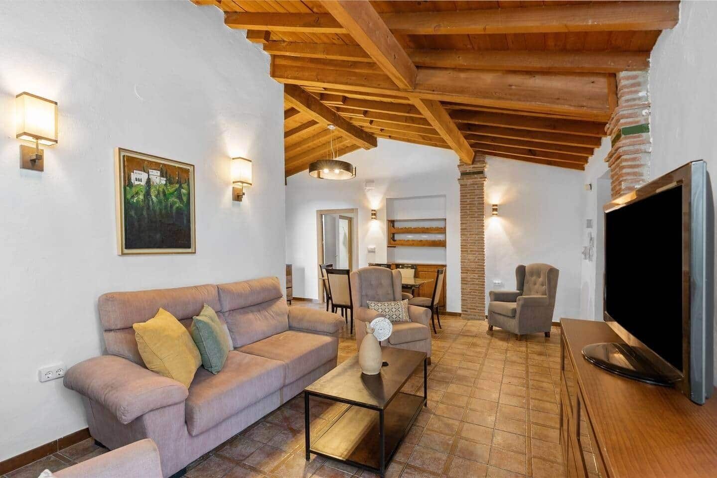 A living room with a sofa, armchairs, a coffee table, a TV, and a dining area with a table and chairs.