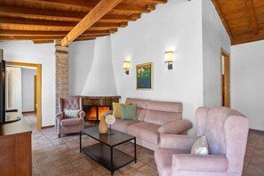A living room with a fireplace, a sofa set, a coffee table, and a wooden ceiling. - Comeback Cortijo Vista Alegre (Motril)