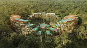 Ein Resort mit mehreren Gebäuden, einem zentral gelegenen Pool und üppiger, umgebender Bepflanzung.