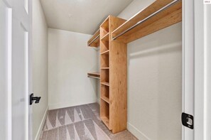 Un dressing avec des étagères en bois et une tringle en métal.