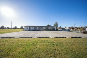 A parking lot with a building in the background. - Dusky Rugby Unit - Te Anau Holiday Home (Te Anau)