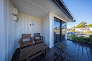 A covered porch with wooden benches and a view of a street. - Dusky Mustering Unit - Te Anau Holiday Home (Te Anau)