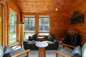 A cozy cabin interior with a sofa set, a table, and a radio. - The Log Cab-Inn - Hot Tub - Game Room - PS5 - Poconos Gem - Rustic Luxury (Albrightsville)