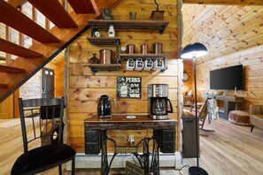 Ein rustikales Holzinterieur mit einer Kaffeestation, einem Schild mit der Aufschrift 'The Pirk's are best here' und einem an der Wand befestigten Fernseher.