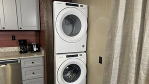A kitchen with a dishwasher, a coffee maker, and two stacked washing machines. - Ward Loft 2 (Fireplace, King Bed, Smart TV) (Canton)