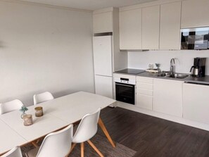 A modern kitchen with white cabinetry, a built-in oven, and a coffee maker. - 5 Star Holiday Home in Uddevalla (Uddevalla)