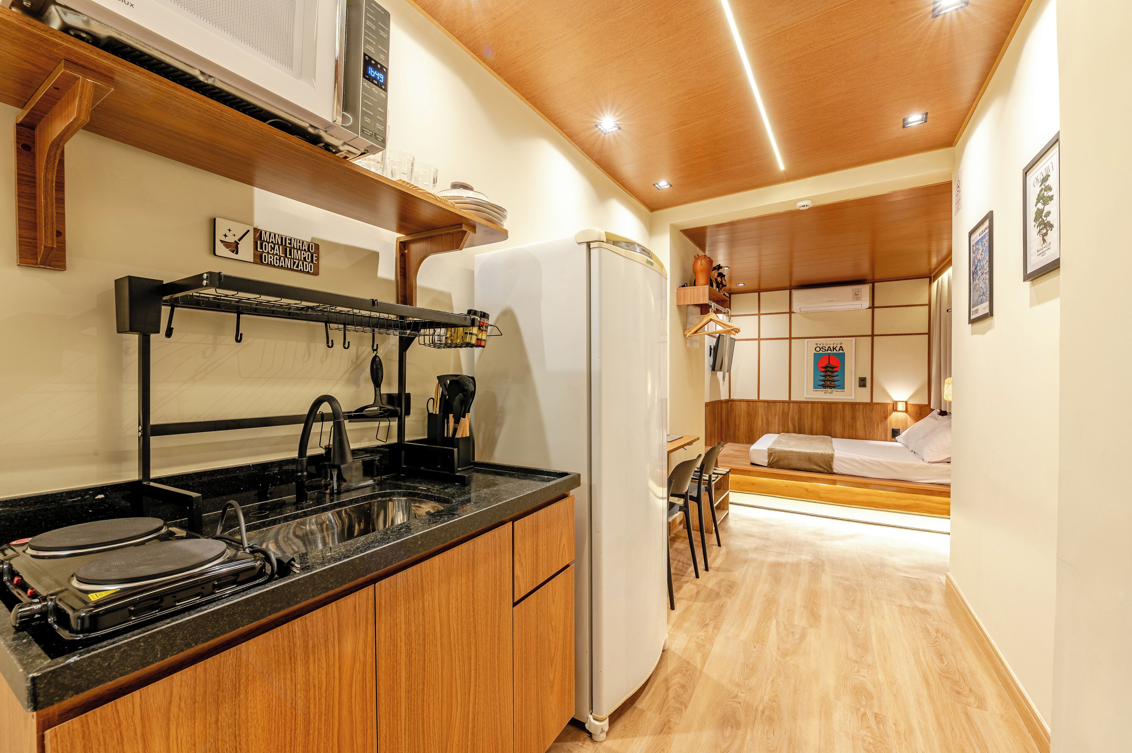 A compact kitchen with a stove, sink, and a refrigerator.