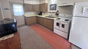 A kitchen with a refrigerator, stove, sink, and cabinets. - 3-bedroom Waterview cabin with AC in charming Birchwood | Waterview Cabin with Private Boat Slip (Birchwood)