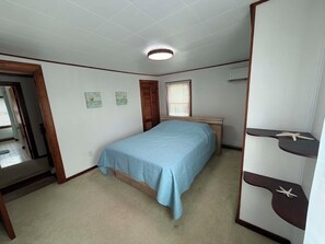 A bedroom with a single bed, a wooden wardrobe, and a ceiling light. - Charming Water-Front Cottage Perfectly Suited for Rest, Relaxation, and Leisure (Chesapeake City)