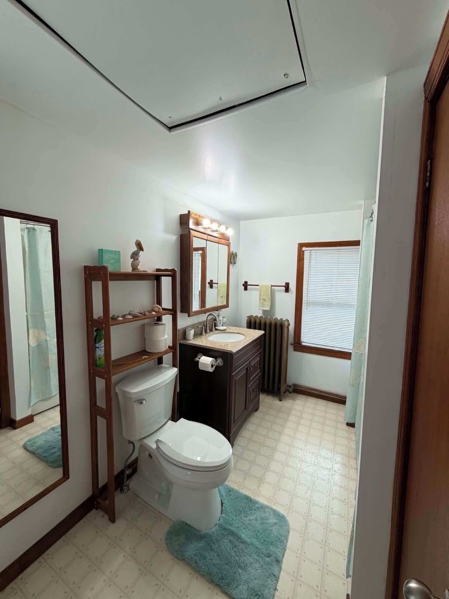 Ein Badezimmer mit Toilette, Waschbecken, Waschtisch und Spiegel.