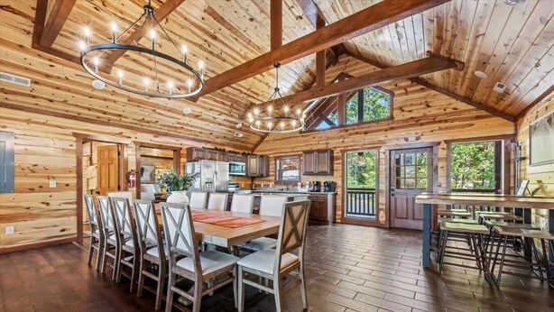 A spacious log cabin interior with a dining area, kitchen, and bar. - Sleeps ~22, Heated Indoor Pool, Hot Tub, Game Room (Sevierville)