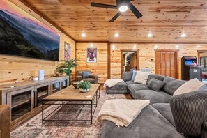 A cozy living room with a sofa, coffee table, and a fireplace. - Sleeps ~22, Heated Indoor Pool, Hot Tub, Game Room (Sevierville)