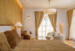 A hotel room with a large bed, a sitting area with a chair and a table, a floor lamp, and a large window with curtains. - Beachfront Villa Adriatic Z with Pool (Žaborić)