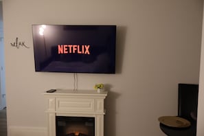 A television mounted on a wall with the word 'NETFLIX' displayed on the screen. - Entire guest apartment 1BR- close to West Edmonton Mall for long/short term rent (Edmonton)