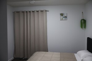 A bedroom with a bed, curtains, a wall-mounted plant, and a painting. - Entire guest apartment 1BR- close to West Edmonton Mall for long/short term rent (Edmonton)