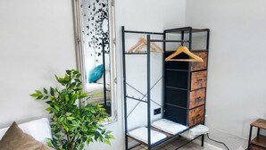 A room with a metal wardrobe, a hanging rack, a plant, and a bed. - London Southeast Modern Stay (London)