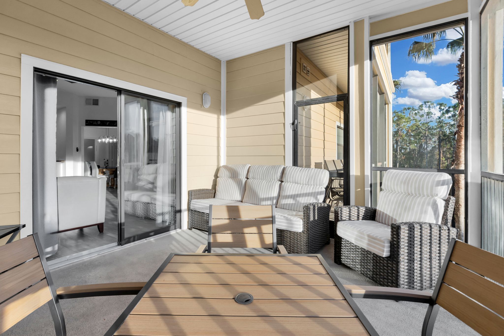 Un patio techado con un sofá, sillas y una mesa.
