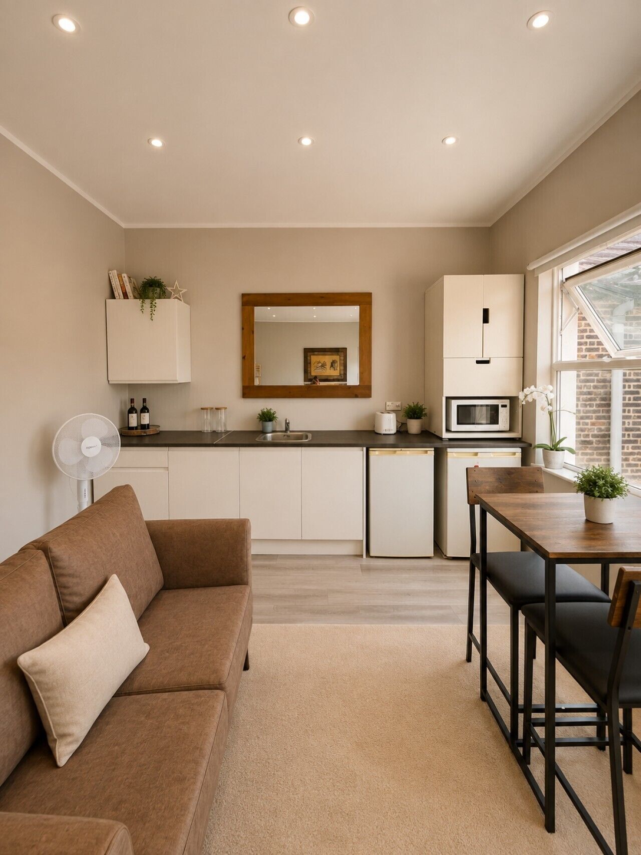 Una cocina moderna con comedor, un sofá y un ventilador.