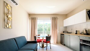 A modern living room with a sofa and a dining table with chairs. - Opal 11 Apartment (Cannes)
